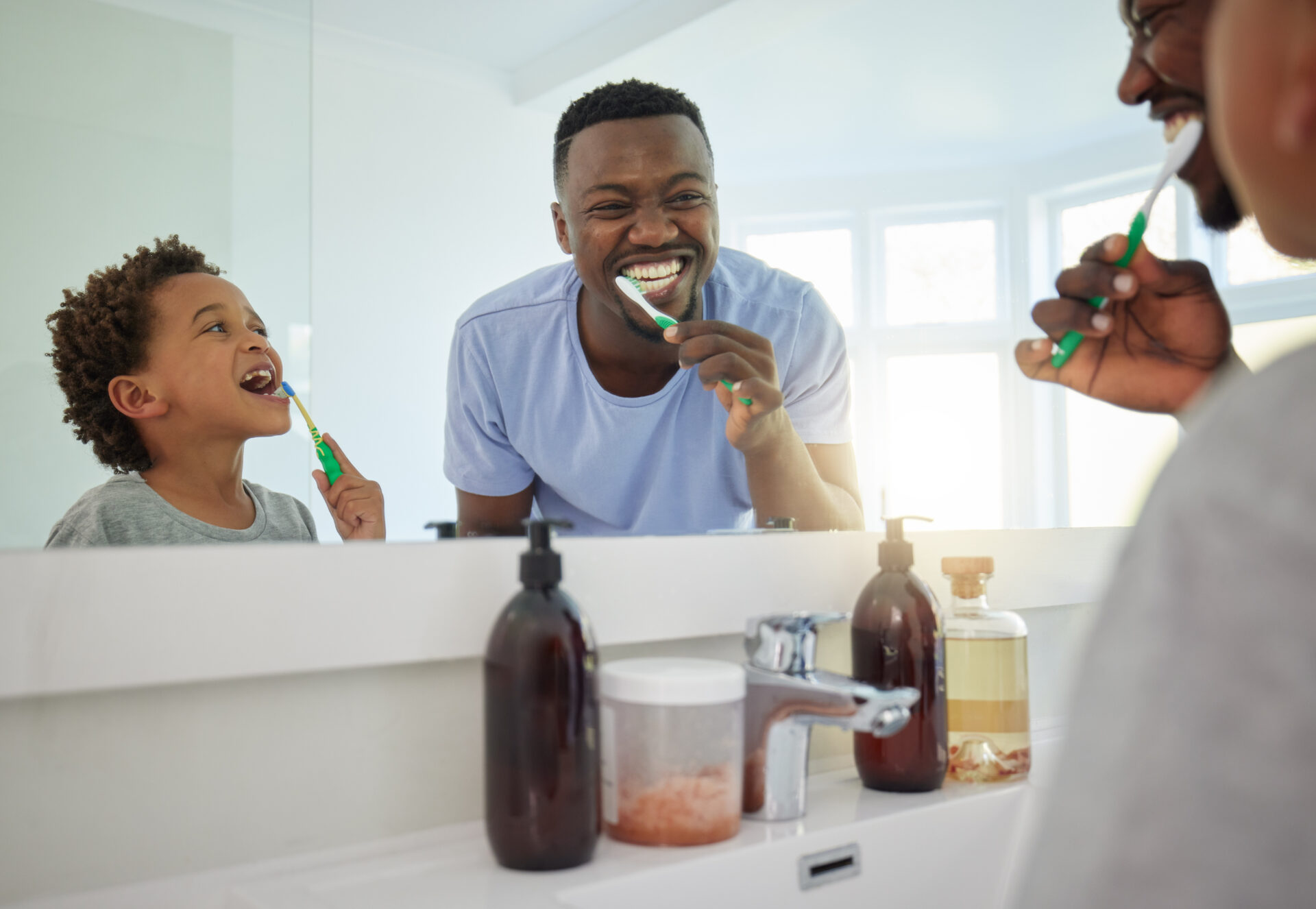 happy father and son brushing teeth